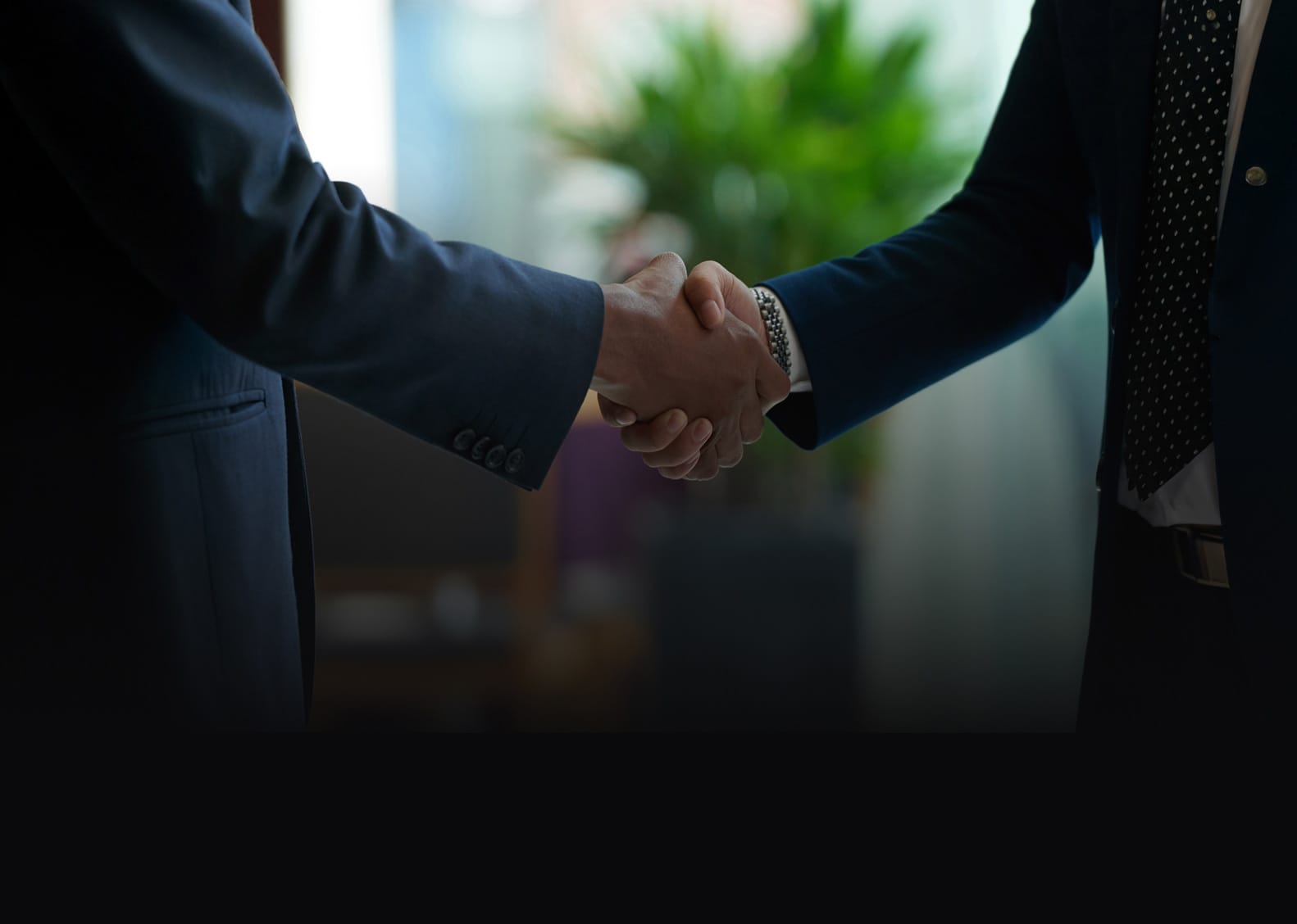 A close-up of two business professionals shaking hands, symbolizing a finalized distributor partnership.